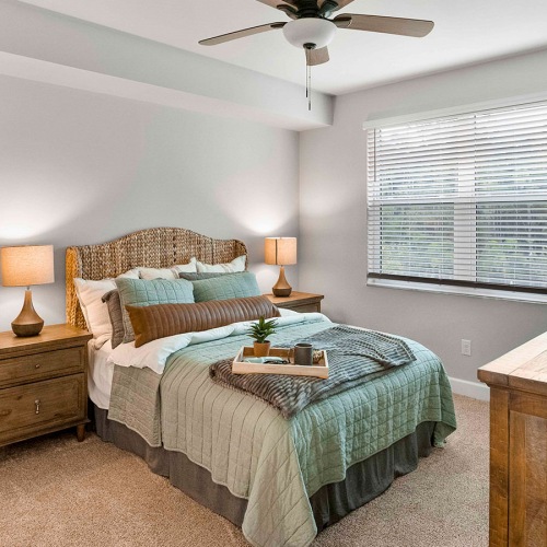Plush carpeting in the bedrooms carpeted bedroom with large window and ceiling fan and light fixture